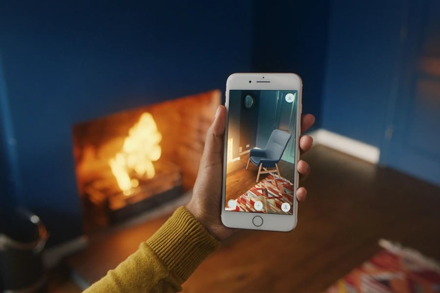 Woman using augmented reality to envision a chair in a room